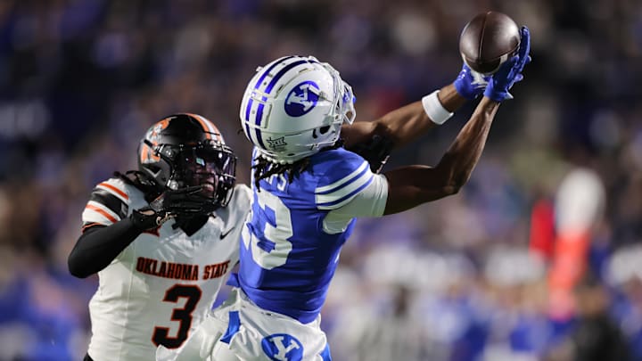 Oct 18, 2024; Provo, Utah, USA; Brigham Young Cougars wide receiver Jojo Phillips (13) reaches for a pass against Oklahoma State Cowboys cornerback Cam Smith (3) during the first quarter at LaVell Edwards Stadium. Mandatory Credit: Rob Gray-Imagn Images