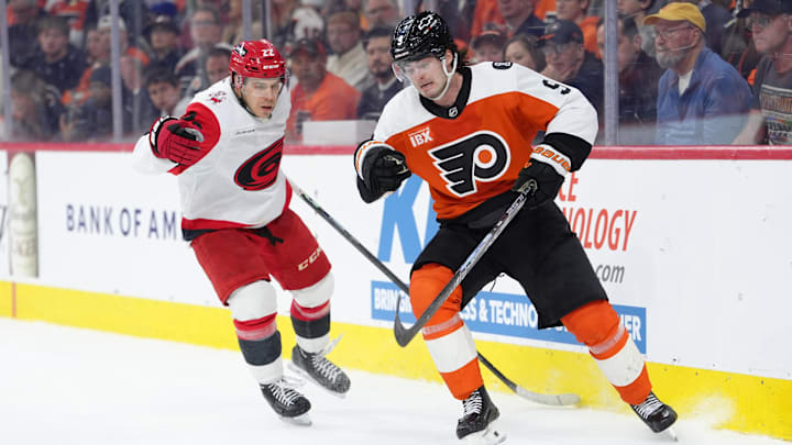 Apr 13, 2026; Philadelphia, Pennsylvania, USA; Philadelphia Flyers defenseman Jamie Drysdale (9) battles for the puck against Carolina Hurricanes center Logan Stankoven (22) in the second period at Xfinity Mobile Arena. 