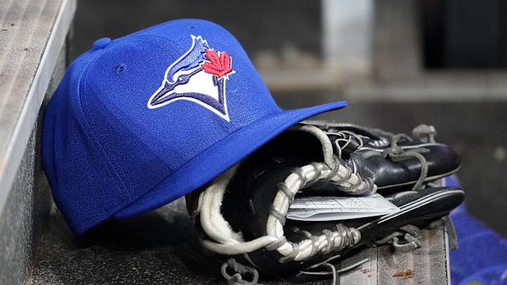 Apr 16, 2025; Toronto, Ontario, CAN; A Toronto Blue Jays hat and glove in the dugout during a game against the Atlanta Braves at Rogers Centre. Mandatory Credit: John E. Sokolowski-Imagn Images
