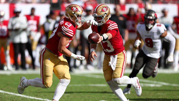 Nov 10, 2024; Tampa, Florida, USA; San Francisco 49ers quarterback Brock Purdy (13) hands off to running back Christian McCaffrey (23) against the Tampa Bay Buccaneers in the third quarter at Raymond James Stadium. Mandatory Credit: Nathan Ray Seebeck-Imagn Images