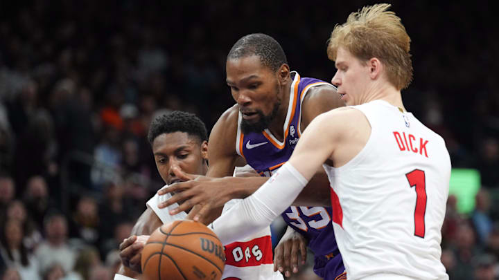 Mar 7, 2024; Phoenix, Arizona, USA; Phoenix Suns forward Kevin Durant (35) dribbles against Toronto Raptors guard RJ Barrett (9) and Toronto Raptors guard Gradey Dick (1) during the second half at Footprint Center. Mandatory Credit: Joe Camporeale-Imagn Images