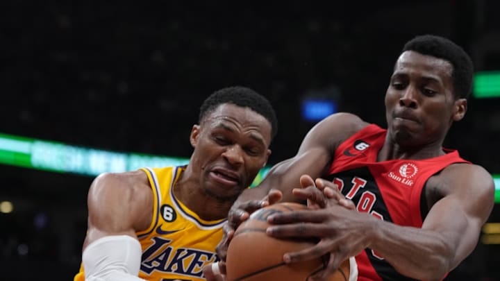 Dec 7, 2022; Toronto, Ontario, CAN; Los Angeles Lakers guard Russell Westbrook (0) battles for the ball with Toronto Raptors forward Christian Koloko (35) during the second quarter at the Scotiabank Arena.  Mandatory Credit: Nick Turchiaro-Imagn Images