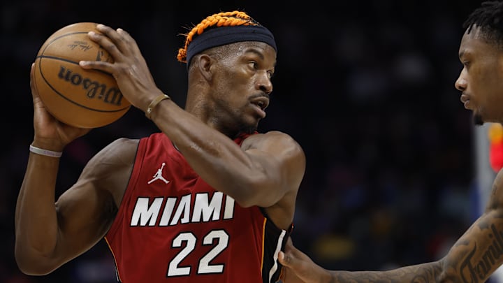 Dec 16, 2024; Detroit, Michigan, USA;  Miami Heat forward Jimmy Butler (22) controls the ball as Detroit Pistons forward Ronald Holland II (00) defends in the first half at Little Caesars Arena. Mandatory Credit: Rick Osentoski-Imagn Images