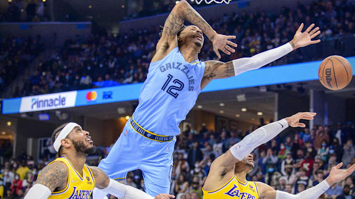 Dec 29, 2021; Memphis, Tennessee, USA; Memphis Grizzlies guard Ja Morant (12) is fouled as he drives to the basket past Los Angeles Lakers forward Carmelo Anthony (7) and guard Russell Westbrook (0) during the second half at the FedExForum. Mandatory Credit: Jerome Miron-Imagn Images