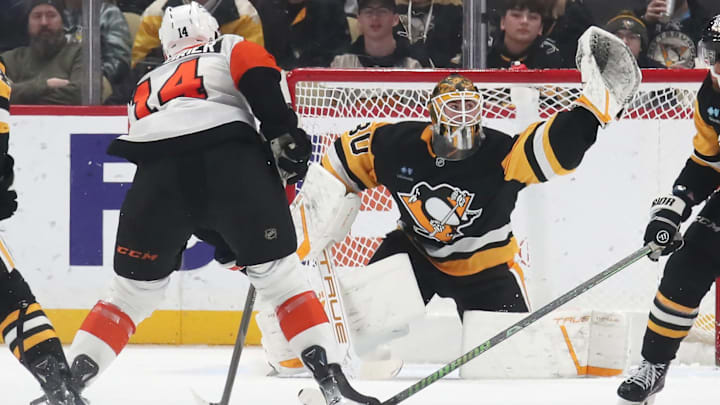Feb 27, 2025; Pittsburgh, Pennsylvania, USA;  Pittsburgh Penguins goaltender Joel Blomqvist (30) makes a glove save against Philadelphia Flyers center Sean Couturier (14) during the third period at PPG Paints Arena. Mandatory Credit: Charles LeClaire-Imagn Images