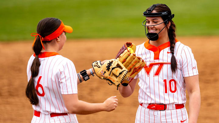 Addyson Fisher (10) and Jordan Lynch (16) tap gloves as Fisher settles into the circle.