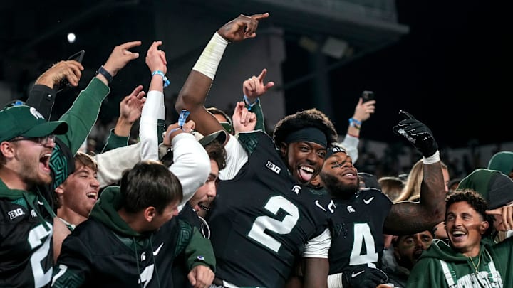 Michigan State's Aidan Chiles, center, and Marcellius Pulliam, right, celebrate with fans in the student section after MSU's win over Boston College on Saturday, Sept. 6, 2025, at Spartan Stadium in East Lansing.