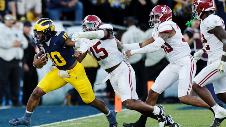Dallas Turner reaches out for a tackle against Michigan.