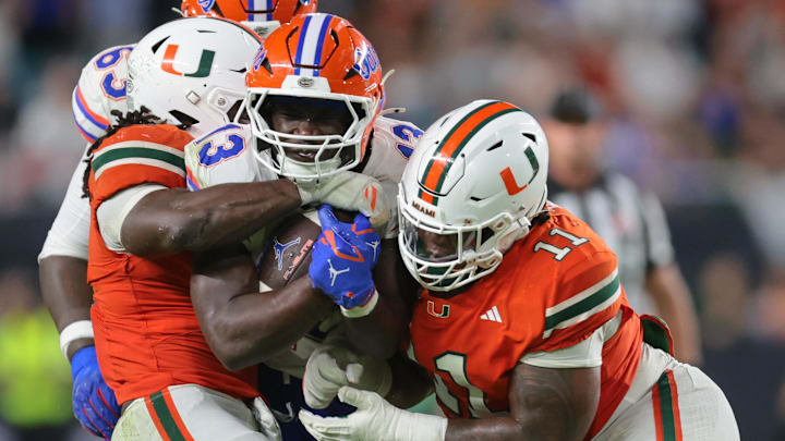 Sep 20, 2025; Miami Gardens, Florida, USA; Florida Gators running back Jadan Baugh (13) carries the football against Miami Hurricanes defensive lineman David Blay Jr. (11) during the third quarter at Hard Rock Stadium. Mandatory Credit: Sam Navarro-Imagn Images