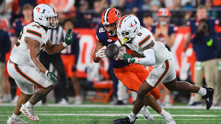 Nov 30, 2024; Syracuse, New York, USA; Miami Hurricanes defensive back Mishael Powell (0) breaks up a pass intended for Syracuse Orange tight end Oronde Gadsden II (19) during the first half at the JMA Wireless Dome. Mandatory Credit: Rich Barnes-Imagn Images
