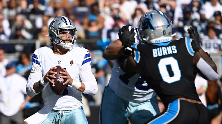 Dallas Cowboys quarterback Dak Prescott looks to pass as Carolina Panthers linebacker Brian Burns at Bank of America Stadium 
