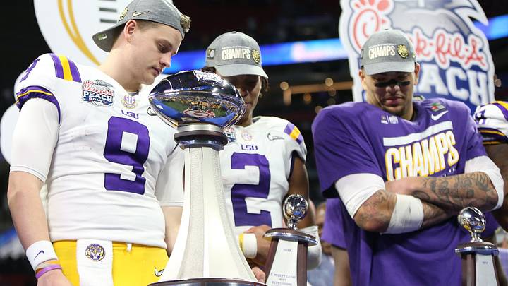 Dec 28, 2019; Atlanta, Georgia, USA; LSU Tigers quarterback Joe Burrow (9) and wide receiver Justin Jefferson (2) and tight end Thaddeus Moss (81) look at the trophy after defeating the Oklahoma Sooners in the 2019 Peach Bowl college football playoff semifinal game at Mercedes-Benz Stadium. Mandatory Credit: Brett Davis-USA TODAY Sports