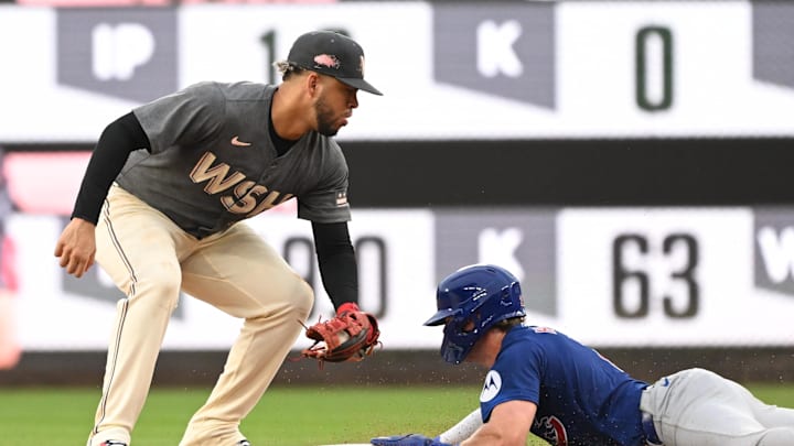Chicago Cubs second baseman Nico Hoerner (2) dives safely into second base in front of Washington Nationals second baseman Luis Garcia Jr. (2) during the seventh inning at Nationals Park in 2024.