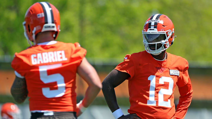 Cleveland Browns quarterback Shedeur Sanders (12) watches quarterback Dillon Gabriel (5) during day two of NFL rookie minicamp at the Cleveland Browns training facility on Saturday, May 10, 2025, in Berea, Ohio.
