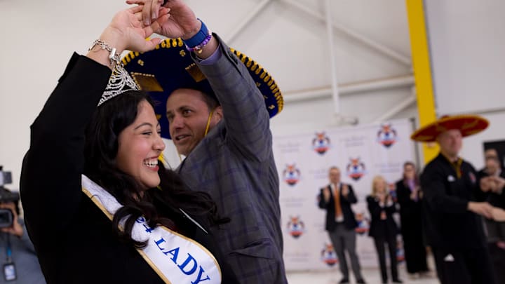 Ashley Rios, the Lady in Waiting for the 2024 Sun Court, dances with Jedd Fisch, Washington's head football coach, as he arrived in El Paso on Thursday, Dec. 26, 2024, for the 2024 Tony the Tiger Sun Bowl.