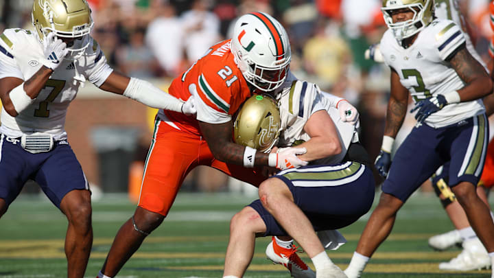 Nov 9, 2024; Atlanta, Georgia, USA; Miami Hurricanes linebacker Jaylin Alderman (21) tackles Georgia Tech Yellow Jackets quarterback Haynes King (10) in the fourth quarter at Bobby Dodd Stadium at Hyundai Field. Mandatory Credit: Brett Davis-Imagn Images