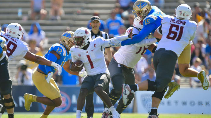 Oct 7, 2023; Pasadena, California, USA; Washington State Cougars quarterback Cameron Ward moves with the ball against UCLA Bruins pass rusher Laiatu Latu and others.