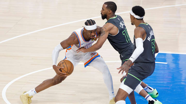 Oklahoma City Thunder guard Shai Gilgeous-Alexander dribbles against Minnesota Timberwolves guard Mike Conley and forward Jaden McDaniels (3) in the first quarter during Game 1 of the Western Conference finals at Paycom Center in Oklahoma City on May 20, 2025. 