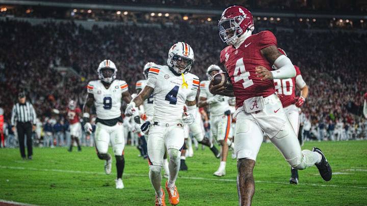 Nov 30, 2024; Tuscaloosa, Alabama, USA; Alabama Crimson Tide quarterback Jalen Milroe (4) scores a touchdown against the Auburn Tigers during the third quarter at Bryant-Denny Stadium. Nov 30, 2024; Tuscaloosa, Alabama, USA; Alabama Crimson Tide quarterback Jalen Milroe (4) scores a touchdown against the Auburn Tigers during the third quarter at Bryant-Denny Stadium.