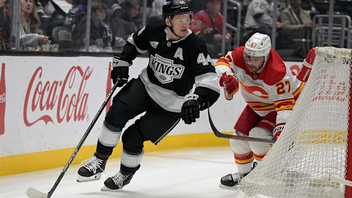 Apr 17, 2025; Los Angeles, California, USA;  Los Angeles Kings defenseman Mikey Anderson (44) keeps the puck from Calgary Flames right wing Matt Coronato (27) in the first period at Crypto.com Arena. Mandatory Credit: Jayne Kamin-Oncea-Imagn Images