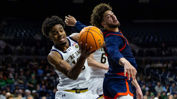 Jan 27, 2026; South Bend, Indiana, USA; Notre Dame Fighting Irish forward Jalen Haralson (10) grabs a rebound away from Virginia Cavaliers guard Sam Lewis (5) during the first overtime at Purcell Pavilion at the Joyce Center. Mandatory Credit: Michael Caterina-Imagn Images