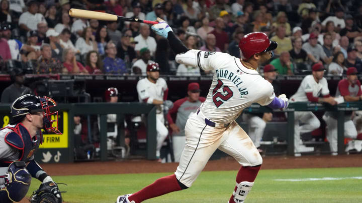 Jul 8, 2024; Phoenix, Arizona, USA; Arizona Diamondbacks outfielder Lourdes Gurriel Jr. (12) hits a sacrifice fly out against the Atlanta Braves in the sixth inning at Chase Field. Mandatory Credit: Rick Scuteri-USA TODAY Sports