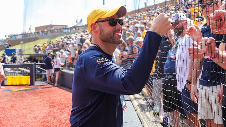 Jun 5, 2026; Morgantown, WV, USA; West Virginia Mountaineers athletic director Wren Baker celebrates with Pat McAfee after defeating the Cal Poly Mustangs at Kendrick Family Ballpark. Mandatory Credit: Ben Queen-Imagn Images