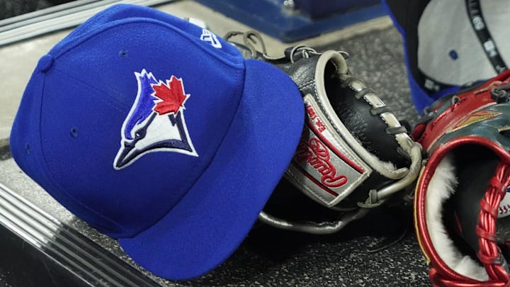 Apr 27, 2024; Toronto, Ontario, CAN; A pair of Toronto Blue Jays hats and gloves in the dugout during the first inning against the Los Angeles Dodgers at Rogers Centre.