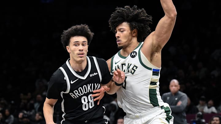 Dec 14, 2025; Brooklyn, New York, USA; Brooklyn Nets guard Nolan Traore (88) dribbles as Milwaukee Bucks center Jericho Sims (00) defends during the second half at Barclays Center. Mandatory Credit: John Jones-Imagn Images