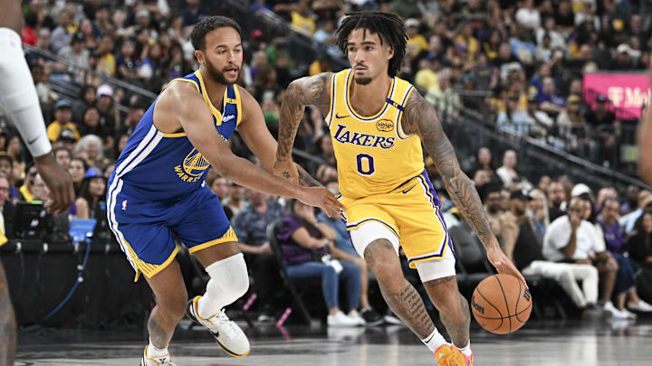 Oct 15, 2024; Las Vegas, Nevada, USA; Los Angeles Lakers guard Jalen Hood-Schifino (0) drives past Golden State Warriors forward Kyle Anderson (1) in the third quarter during a preseason game at T-Mobile Arena. Mandatory Credit: Candice Ward-Imagn Images