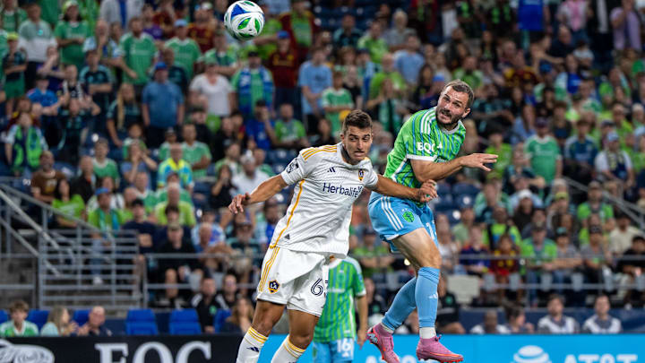 Sep 13, 2025; Seattle, Washington, USA; Seattle Sounders forward Jordan Morris (13) heads the ball against LA Galaxy defender Chris Rindov (63) during the second half at Lumen Field. Mandatory Credit: Stephen Brashear-Imagn Images