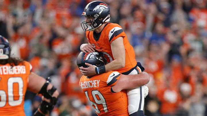 Dec 14, 2025; Denver, Colorado, USA; Denver Broncos quarterback Bo Nix (10) celebrates a touchdown with offensive tackle Mike McGlinchey (69) during the third quarter against the Green Bay Packers at Empower Field at Mile High. 