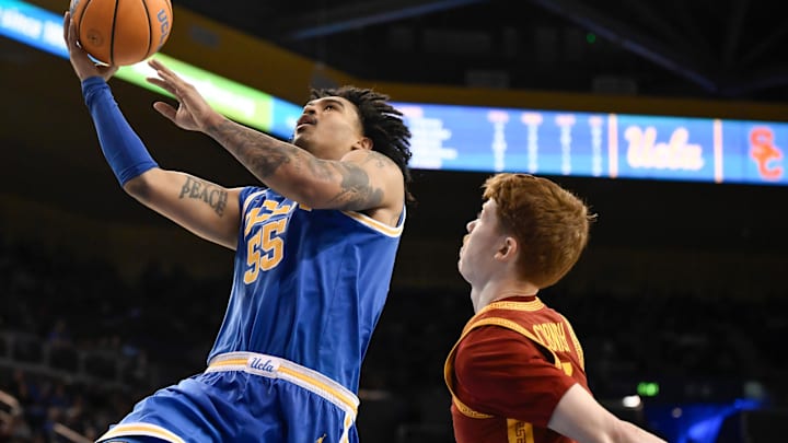Feb 24, 2026; Los Angeles, California, USA; UCLA Bruins guard Skyy Clark (55) drives to the basket past Southern California Trojans guard Ryan Cornish (9) during the second half at Pauley Pavilion presented by Wescom Financial. Mandatory Credit: Robert Hanashiro-Imagn Images