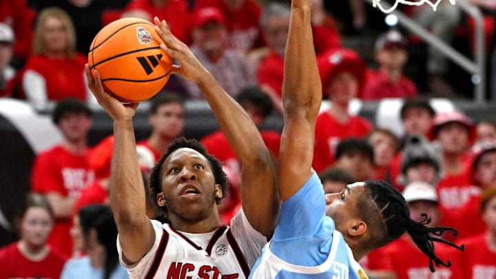 Feb 17, 2026; Raleigh, North Carolina, USA; NC State Wolfpack guard Quadir Copeland (11) lays the ball up against North Carolina Tar Heels forward Jarin Stevenson (15) during the first half at Lenovo Center. Mandatory Credit: Zachary Taft-Imagn Images Feb 17, 2026; Raleigh, North Carolina, USA; NC State Wolfpack guard Quadir Copeland (11) lays the ball up against North Carolina Tar Heels forward Jarin Stevenson (15) during the first half at Lenovo Center. Mandatory Credit: Zachary Taft-Imagn Images