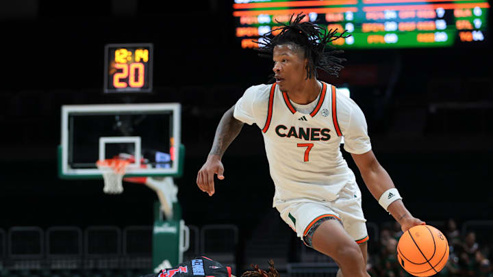 Nov 23, 2025; Coral Gables, Florida, USA; Miami Hurricanes forward Shelton Henderson (7) drives to the basket against Delaware State Hornets guard John Clemmons (5) during the second half at Watsco Center. Mandatory Credit: Sam Navarro-Imagn Images