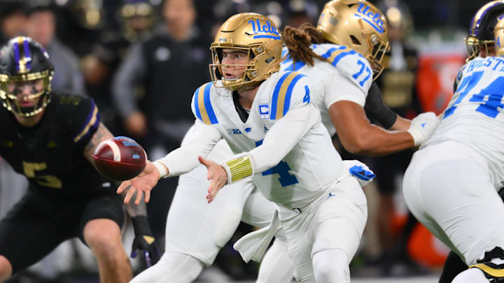 Nov 15, 2024; Seattle, Washington, USA; UCLA Bruins quarterback Ethan Garbers (4) tosses the ball backward during the first half against the Washington Huskies at Alaska Airlines Field at Husky Stadium. Mandatory Credit: Steven Bisig-Imagn Images