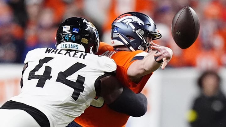 Dec 21, 2025; Denver, Colorado, USA; Jacksonville Jaguars defensive end Travon Walker (44) hits Denver Broncos quarterback Bo Nix (10) during the second half at Empower Field at Mile High. Mandatory Credit: Ron Chenoy-Imagn Images