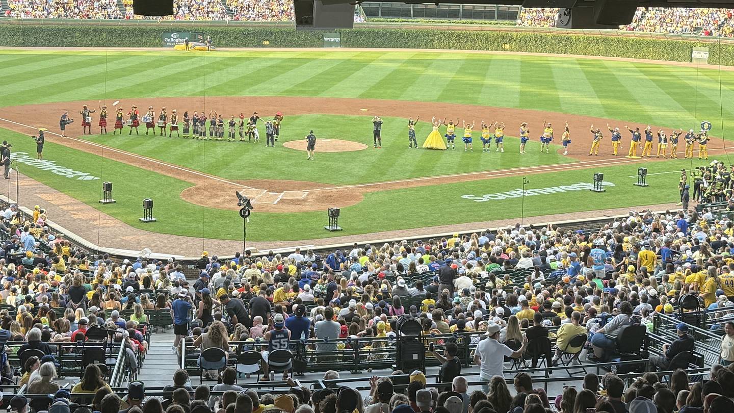 Un campo da baseball con spettacoli programmati e momenti di competizione reale, con pubblico e giocatori coinvolti