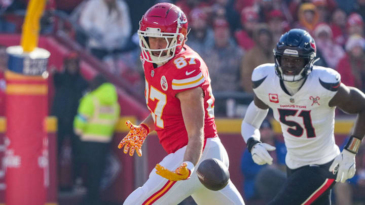 Dec 21, 2024; Kansas City, Missouri, USA; Kansas City Chiefs tight end Travis Kelce (87) fumbles a pass as Houston Texans defensive end Will Anderson Jr. (51) defends during the first half at GEHA Field at Arrowhead Stadium. Mandatory Credit: Denny Medley-Imagn Images