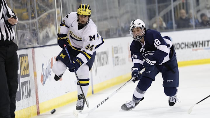 Michigan forward Mark Estapa (94) battles for the puck against Penn State forward Aiden Fink (18)