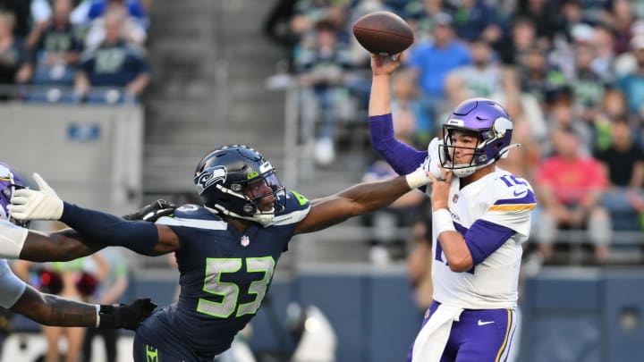 Aug 10, 2023; Seattle, Washington, USA; Minnesota Vikings quarterback Nick Mullens (12) passes the ball while being hit by Seattle Seahawks linebacker Boye Mafe (53) at Lumen Field.