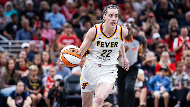 Jul 9, 2025; Indianapolis, Indiana, USA; Indiana Fever guard Caitlin Clark (22) dribbles the ball while Golden State Valkyries guard Tiffany Hayes (15) defends in the first half at Gainbridge Fieldhouse. Mandatory Credit: Trevor Ruszkowski-Imagn Images