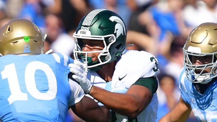 Oct 24, 2026; Pasadena, California, USA; Michigan State Spartans running back Kenneth Williams (32) carries the ball as tight end Jayden Savoury (31) blocks UCLA Bruins linebacker Sammy Omosigho (10) during the first half at Rose Bowl. Mandatory Credit: Gary A. Vasquez-Imagn Images Oct 24, 2026; Pasadena, California, USA; Michigan State Spartans running back Kenneth Williams (32) carries the ball as tight end Jayden Savoury (31) blocks UCLA Bruins linebacker Sammy Omosigho (10) during the first half at Rose Bowl. Mandatory Credit: Gary A. Vasquez-Imagn Images