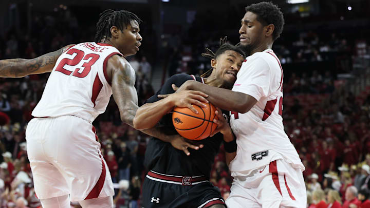 South Carolina guard Meechie Johnson (5) drives between Arkansas forward Nick Pringle (23) and wing Billy Richmond III (24) during the second half at Bud Walton Arena. Arkansas won 108-74. 