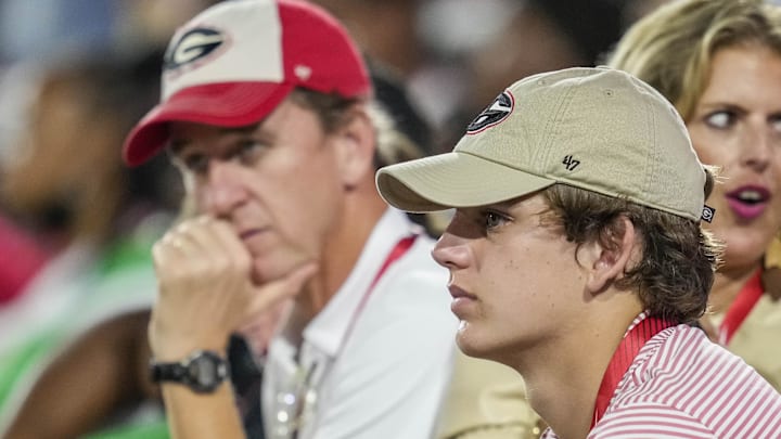 Arch Manning looks on with his parents during a game between the South Carolina Gamecocks against the Georgia Bulldogs at Sanford Stadium.
