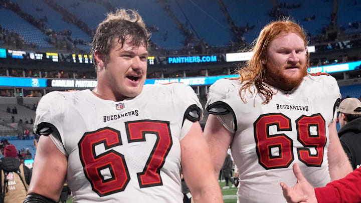 Dec 1, 2024; Charlotte, North Carolina, USA; Tampa Bay Buccaneers offensive tackle Luke Goedeke (67) and guard Cody Mauch (69) leave the field after the game at Bank of America Stadium. Mandatory Credit: Bob Donnan-Imagn Images