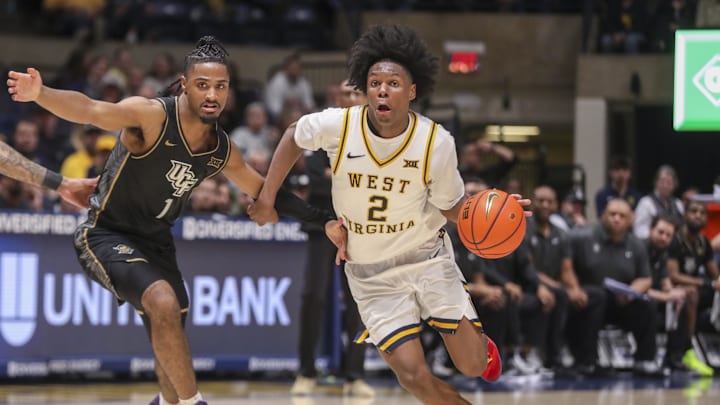 Mar 6, 2026; Morgantown, West Virginia, USA; West Virginia Mountaineers guard Amir Jenkins (2) dribbles past UCF Knights guard Themus Fulks (1) during the second half at Hope Coliseum. Mandatory Credit: Ben Queen-Imagn Images