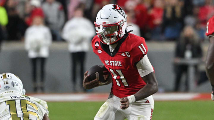 Nov 1, 2025; Raleigh, North Carolina, USA;  North Carolina State Wolfpack quarterback CJ Bailey (11) runs the ball against Georgia Tech Yellow Jackets defensive back Kelvin Hill (16) during the fourth quarter at Carter-Finley Stadium. Mandatory Credit: Zachary Taft-Imagn Images