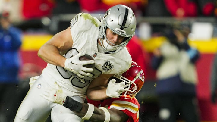 Nov 29, 2024; Kansas City, Missouri, USA; Las Vegas Raiders tight end Brock Bowers (89) runs with the ball against Kansas City Chiefs safety Chamarri Conner (27) during the second half at GEHA Field at Arrowhead Stadium. Mandatory Credit: Jay Biggerstaff-Imagn Images