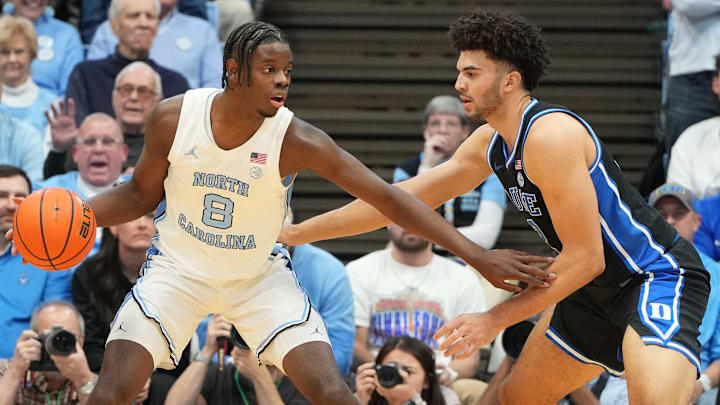 Feb 7, 2026; Chapel Hill, North Carolina, USA; North Carolina Tar Heels forward Caleb Wilson (8) with the ball as Duke Blue Devils forward Cameron Boozer (12) defends in the first  half at Dean E. Smith Center. Mandatory Credit: Bob Donnan-Imagn Images